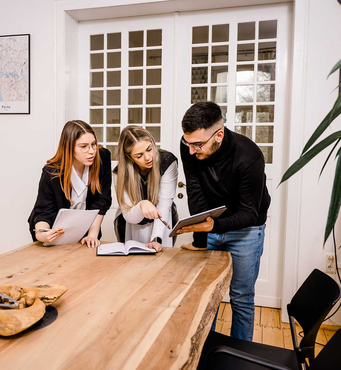 3 Coworker aus Düren unterhalten sich im Besprechungsraum, den man mieten kann.